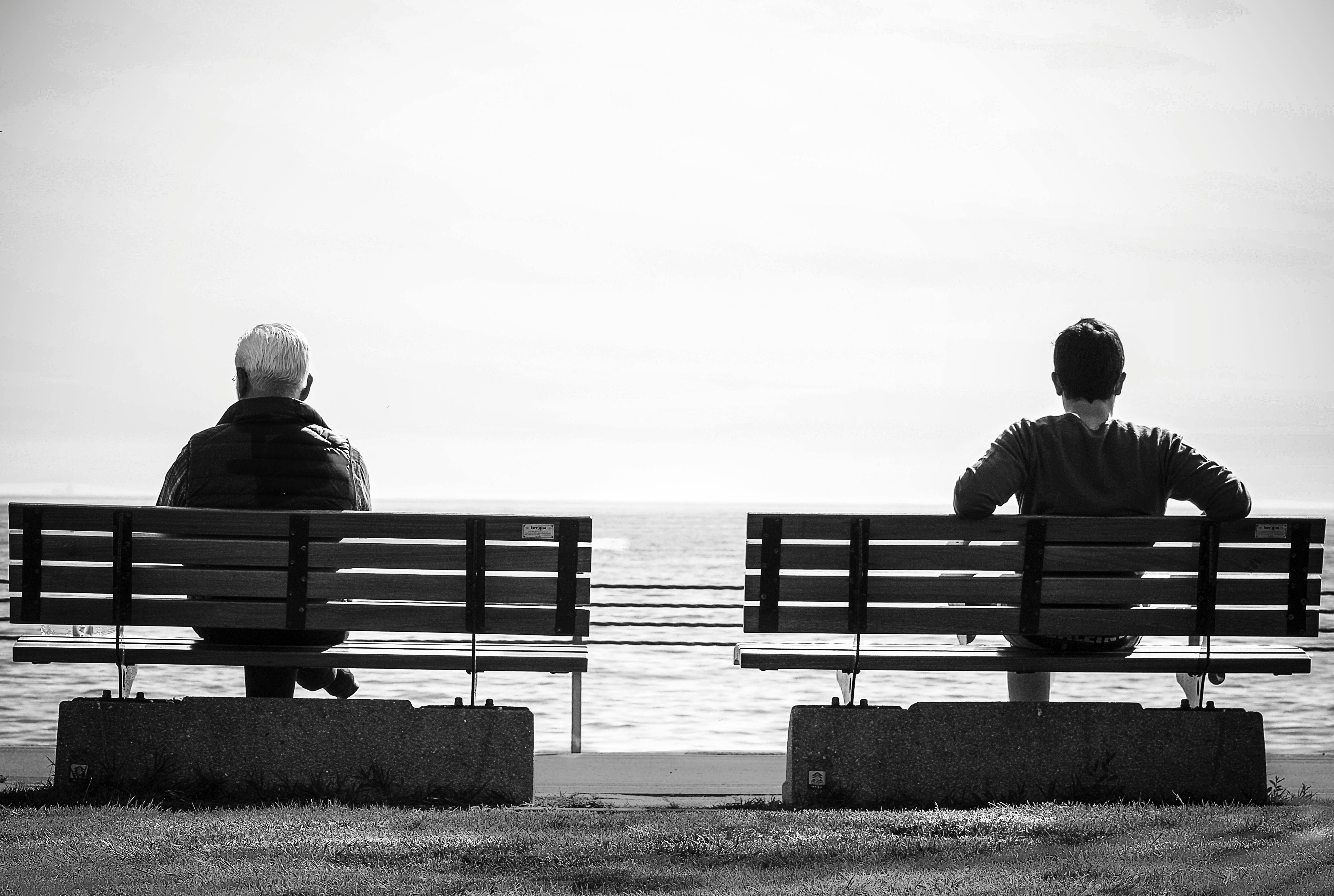 Father and son sitting on separate benches.